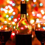 Image: A bottle of red wine with Christmas lights in the background